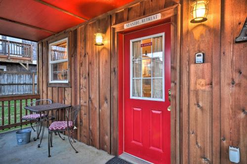 a red door on a wooden cabin with a table and chairs at Cute Studio Abode - Steps to Long Beach Boardwalk! in Long Beach