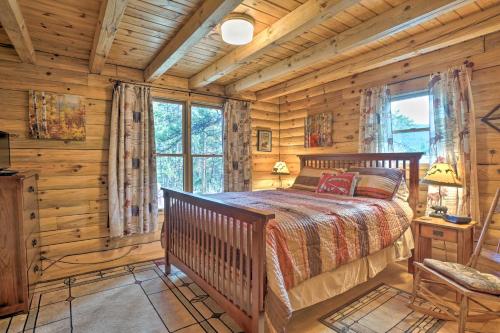 ein Schlafzimmer mit einem Bett in einem Blockhaus in der Unterkunft Picturesque Log Cabin in Estes Park 9 Mi to RMNP in Estes Park