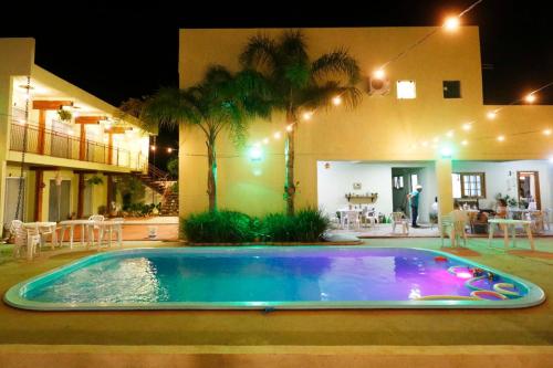 a swimming pool in front of a house at night at Hotel Zona Sul in São Gabriel