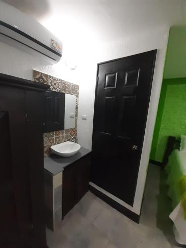 a bathroom with a black door and a sink at Hotel Mi Paraíso Río Dulce in Castillo de San Felipe