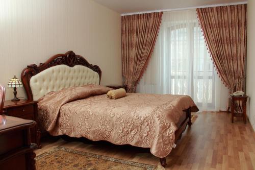 a bedroom with a large bed and a large window at Hotel Aristokrat in Poltava