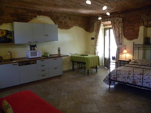 a kitchen and a bedroom with a bed and a table at Agriturismo Fano's Farm in Suno