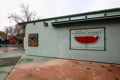 a building with a farmers market sign on it at Well-Appointed Condo Across Street from UC Davis! in Davis