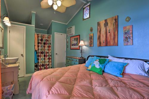 ein Schlafzimmer mit einem Bett mit einer rosa Decke in der Unterkunft Lakeside Pleasure Island Cabin with Deck and Gas Grill in Farmerville