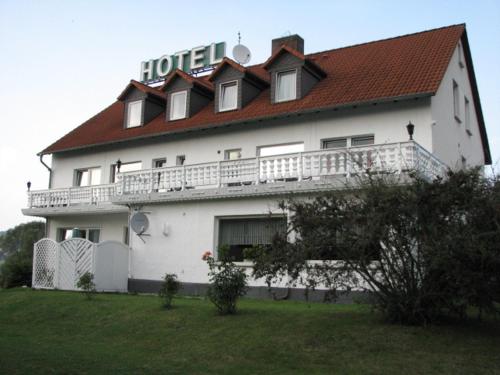 un gran edificio blanco con techo rojo en Hotel Linden, en Knüllwald