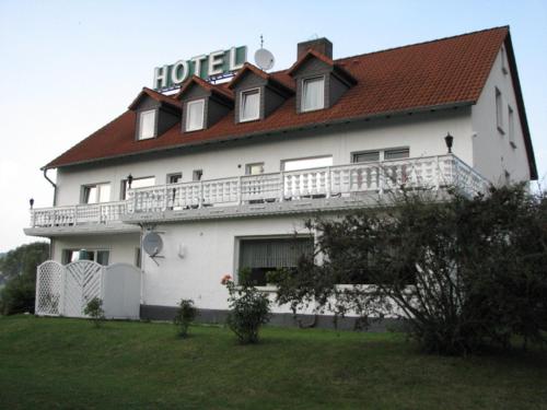 um grande edifício branco com um telhado vermelho em Hotel Linden em Knüllwald