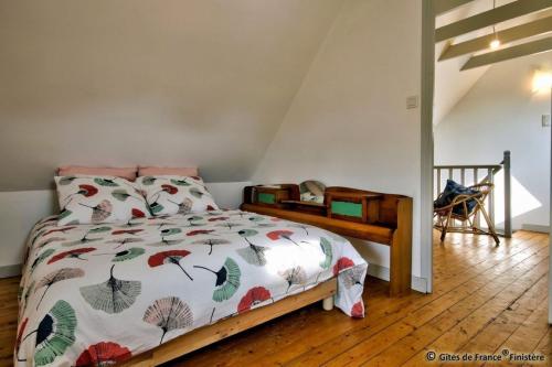 - une chambre avec un lit et une couette avec des feuilles dans l'établissement Gîte Le pied à terre, à Kerlouan