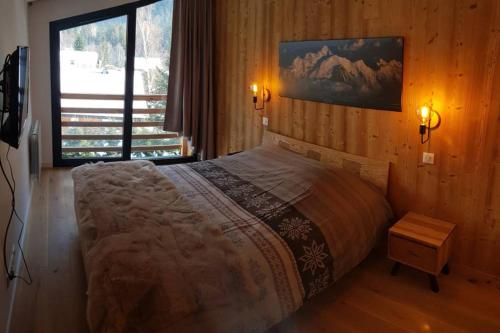 a bedroom with a bed and a large window at Résidence Luxe 5*,Spa & Fitness, La Cordée Appartement 821 in Chamonix-Mont-Blanc