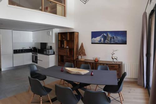 a kitchen with a table and chairs in a room at Résidence Luxe 5*,Spa & Fitness, La Cordée Appartement 821 in Chamonix-Mont-Blanc