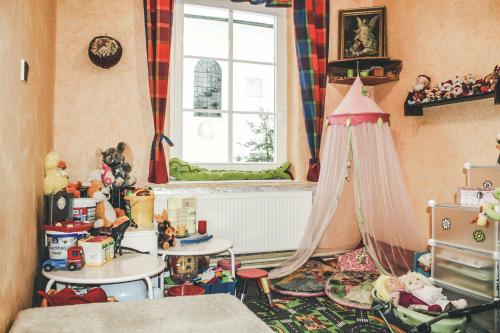 Habitación con cama, ventana y juguetes en Pension Familia, en Harrachov