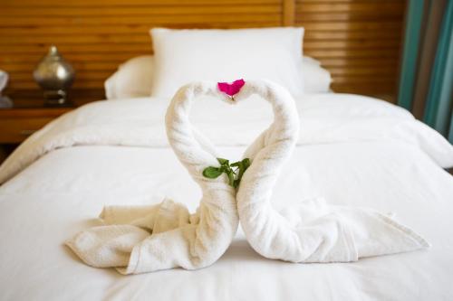 two towels shaped like swans sitting on a bed at Sheikh Ali Dahab Resort in Dahab