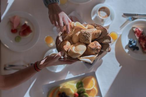 uma pessoa segurando um cesto de comida numa mesa em Hotel Alpenblick em Lutago