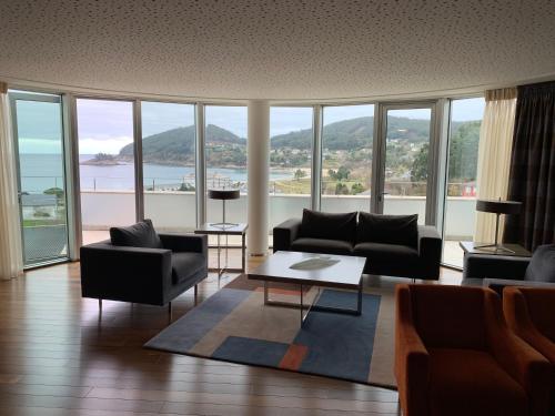 a living room with couches and a large window at Hotel Ego in Viveiro
