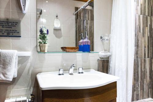 y baño con lavabo blanco y ducha. en Cabañas de la Patagonia en San Martín de los Andes