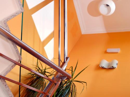 a staircase with an orange wall and a window at Hostal Bajo La Muralla in Zamora