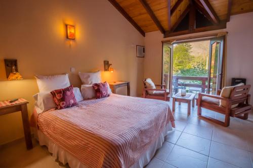 a bedroom with a large bed and a balcony at Posada Shemak in Villa General Belgrano