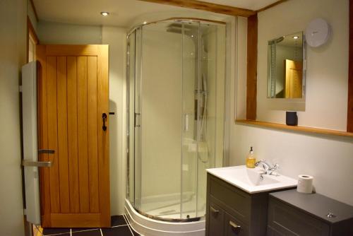 a bathroom with a glass shower and a sink at Tigh a Chabar in Lochaline