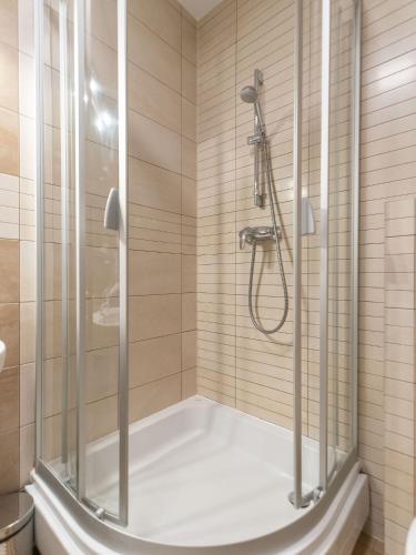a bathroom with a shower and a tub at AquaBaltic Apartments Aquarius in Kołobrzeg