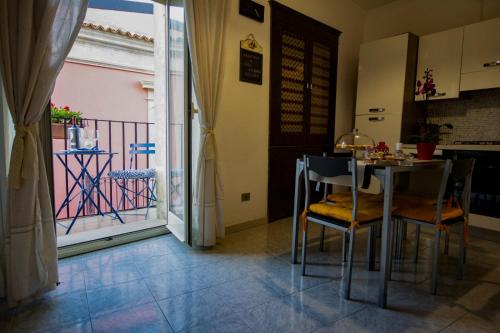 a dining room with a table and chairs and a balcony at Casa Agorà in Palazzolo Acreide