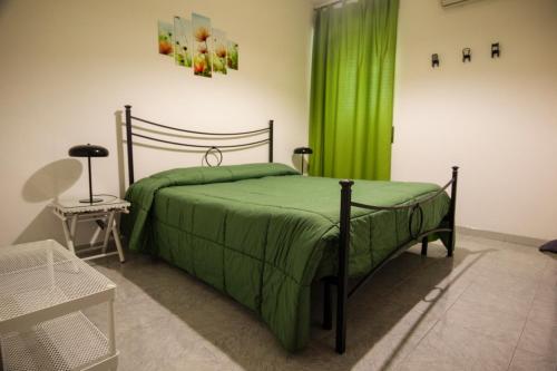 ein Schlafzimmer mit einem Bett und einem grünen Vorhang in der Unterkunft Casa Agorà in Palazzolo Acreide