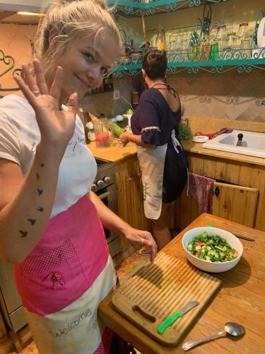 a woman standing in a kitchen with a bowl of salad at Riad Scalia Traditional Guesthouse Fes Morocco in Fès
