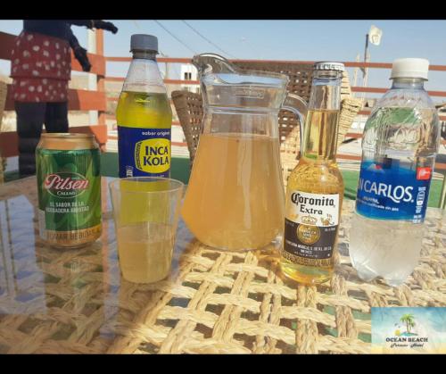 a table with bottles of drinks and a glass of water at Hotel Ocean Beach Paracas in Paracas