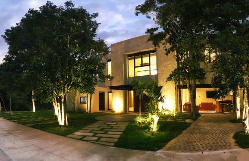 a building with trees in front of it at Xaha Villas Suites & Golf Resort in Tulum