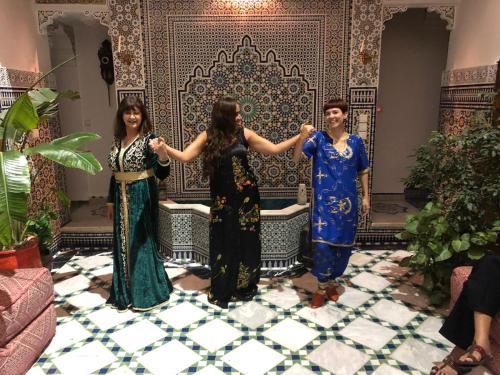 a group of three women standing in front of a wall at Riad Scalia Traditional Guesthouse Fes Morocco in Fès