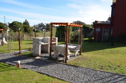 a park with two benches and a gazebo at Complejo de Cabañas lo de Otto , Los Acantilados , Mar del plata in Mar del Plata