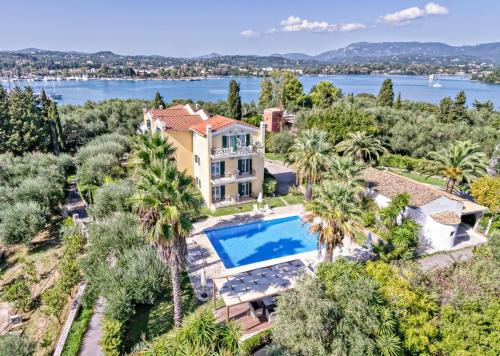 una vista aerea di una casa con piscina e palme di Villa Eftichia Hotel Apartments & Studios a Kontokali