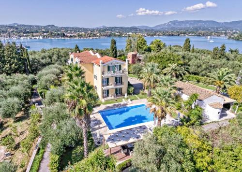 an aerial view of a house with a swimming pool and palm trees at Villa Eftichia Hotel Apartments & Studios in Kontokali