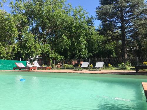 a swimming pool with two chairs and a table at Posada El Cortijo in San Javier