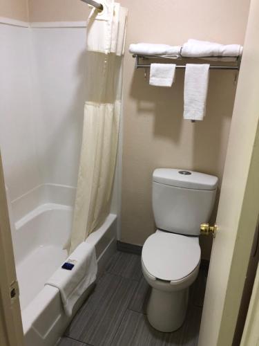 a bathroom with a white toilet and a bath tub at Crossroads Inn in Lebanon