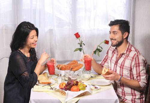 a man and woman sitting at a table eating food at Hotel Huasi Continental in Quito