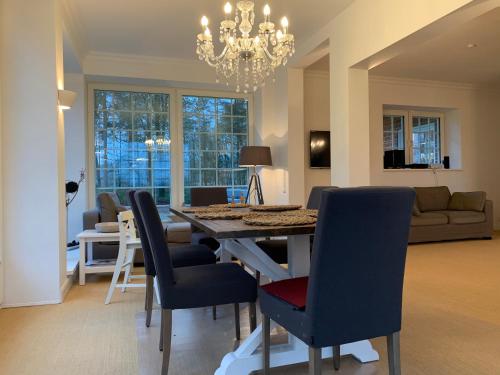 comedor y sala de estar con mesa y sillas en Nordheidehaus - Villa, en Asendorf