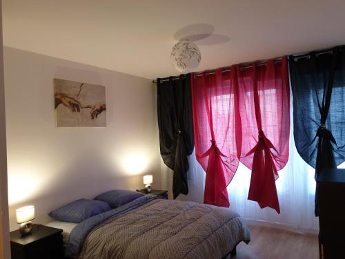 una camera da letto con tende rosse, un letto e una finestra di Grand F3 CONFORTABLE 5 mn de Paris et proche Disneyland a Maisons-Alfort