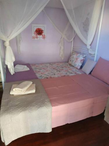 a bedroom with a pink bed with a canopy at cELLATE cozy home in Chalkida