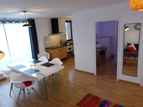 Il comprend un salon avec une table et des chaises ainsi qu'une cuisine. dans l'établissement le 99B Modern apartment queen size bed connected TV, à Hallennes-lès-Haubourdin