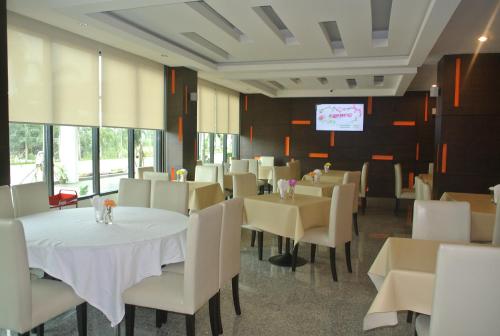 a dining room with white tables and white chairs at S Tara Grand in Suratthani