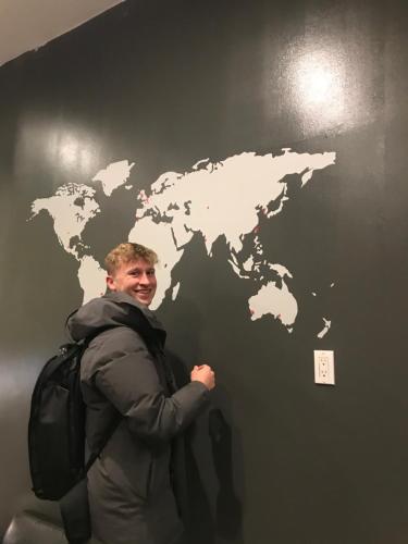 a man with a backpack and a map on a wall at The Clarence Park in Toronto