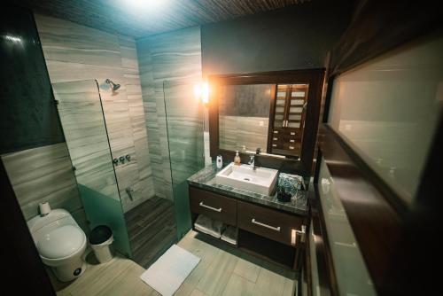 a bathroom with a sink and a shower and a toilet at Hotel Poza Blanca Lodge in San Mateo