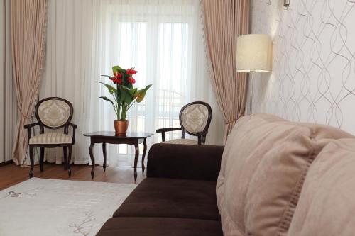 a living room with a couch and a table with a plant at Hotel Aristokrat in Poltava