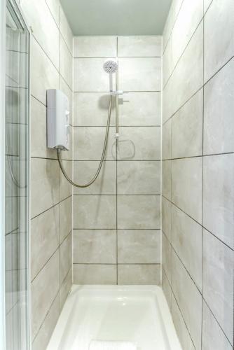 a bathroom with a shower with a tub at Ice Cream Suite in Edinburgh