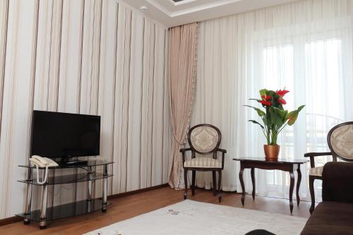 a living room with a television and a table and chairs at Hotel Aristokrat in Poltava
