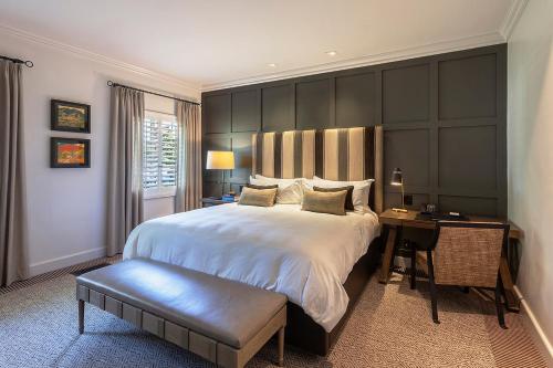 a bedroom with a large bed and a desk at Ojai Valley Inn in Ojai