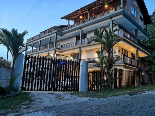 a house with a gate and palm trees in front of it at Kairos Villa in Seremban