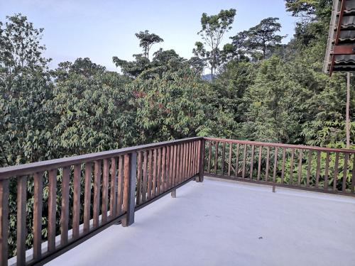 a wooden balcony with trees in the background at Kairos Villa in Seremban