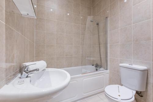 W łazience znajduje się umywalka, toaleta i prysznic. w obiekcie Elicia's South Kensington Apartment w Londynie