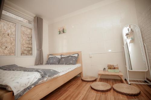 a bedroom with a bed and two stools in it at Homestay BỒ CÔNG ANH in Da Lat