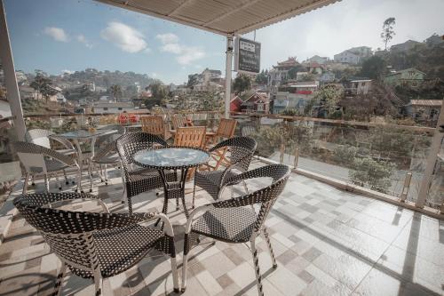 a patio with tables and chairs and a view of a city at Homestay BỒ CÔNG ANH in Da Lat